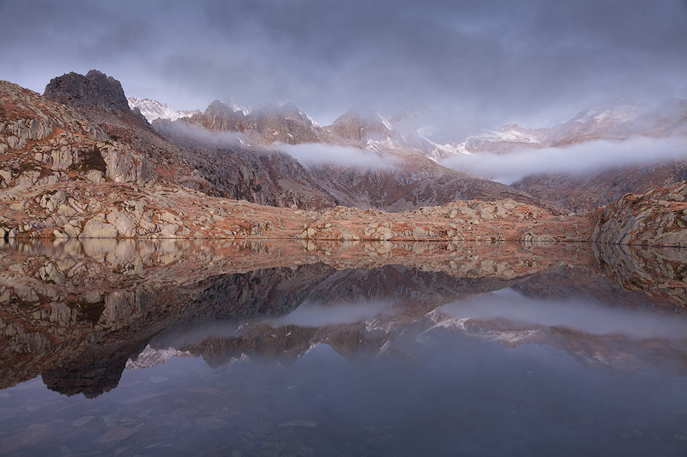 Nebbie e nuvole basse creano un'atmosfera mistica al lago Nero di Cornisello, in alta Val Nambrone, nel Parco Naturale Adamello-Brenta